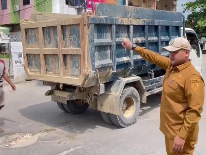 Camat Ujung Batu Rio terlihat membantu    arus lalu lintas saat perbaikan jalan