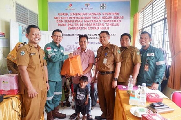 Rafiq Adriansyah selaku Head of Field Support PT SPR Langgak menyerahkan PMT, disaksikan Muhammad Rodi, Camat Tandun dan Aan Mardianto, Kepala Puskesmas Tandun 1