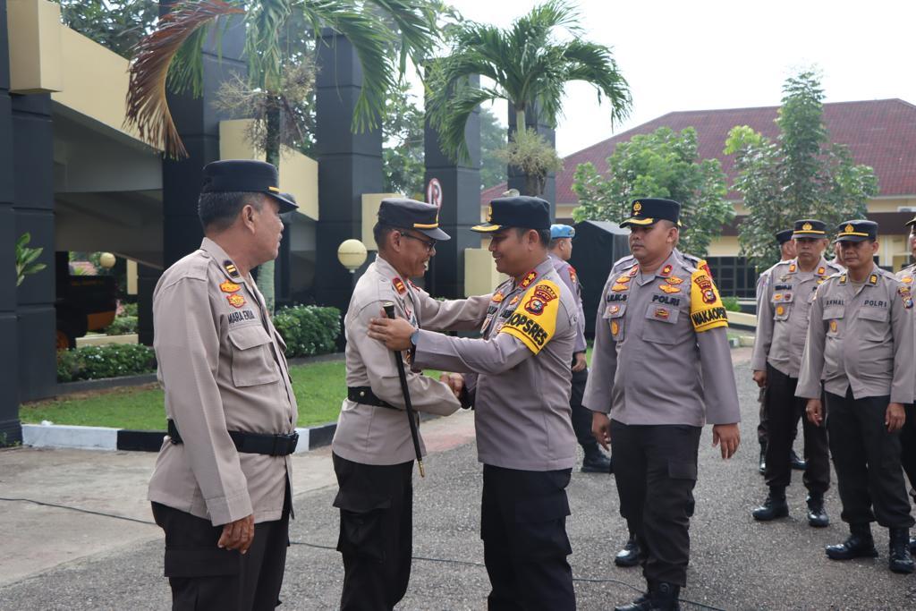 AKBP Pangucap menjabat tangan salah seorang personil yang purna bhakti