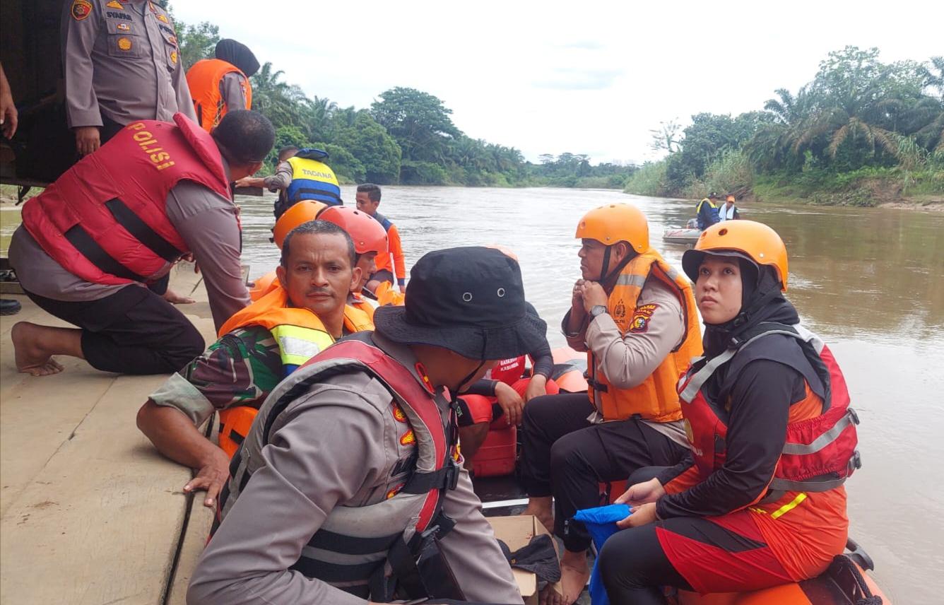 Personil menaiki perahu karet untuk mencari korban hanyut