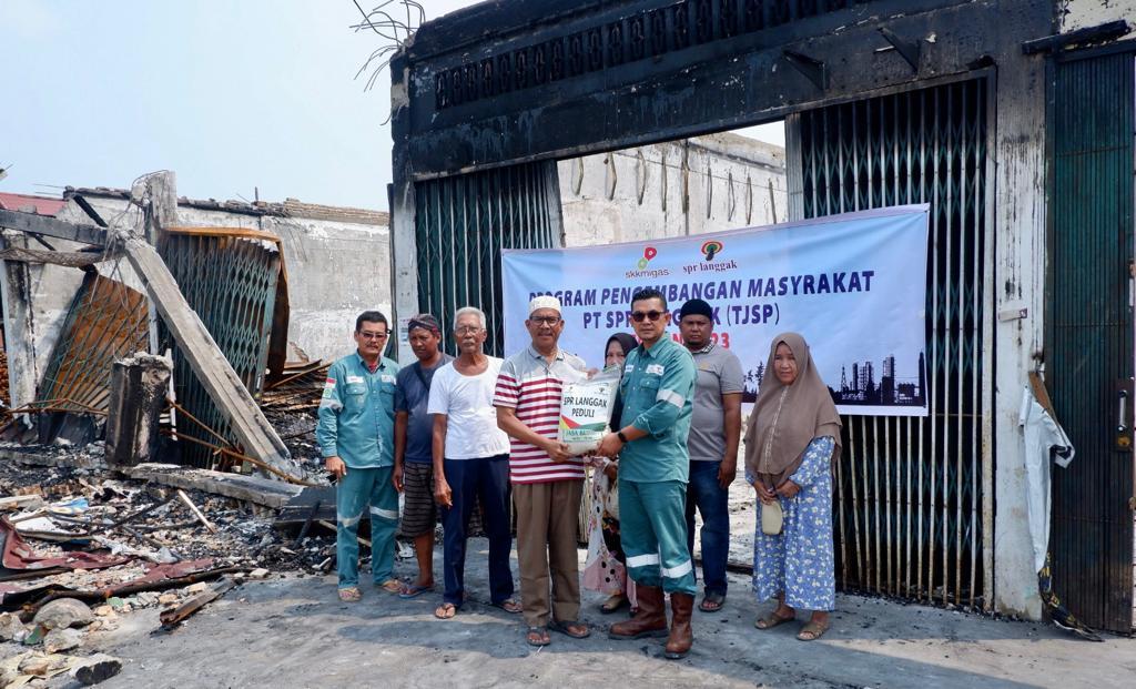 Rafiq Adriansyah didampingi Hardi menyerahkan bantuan kepada Mujahidi selaku Koordinator Posko Bantuan Kebakaran