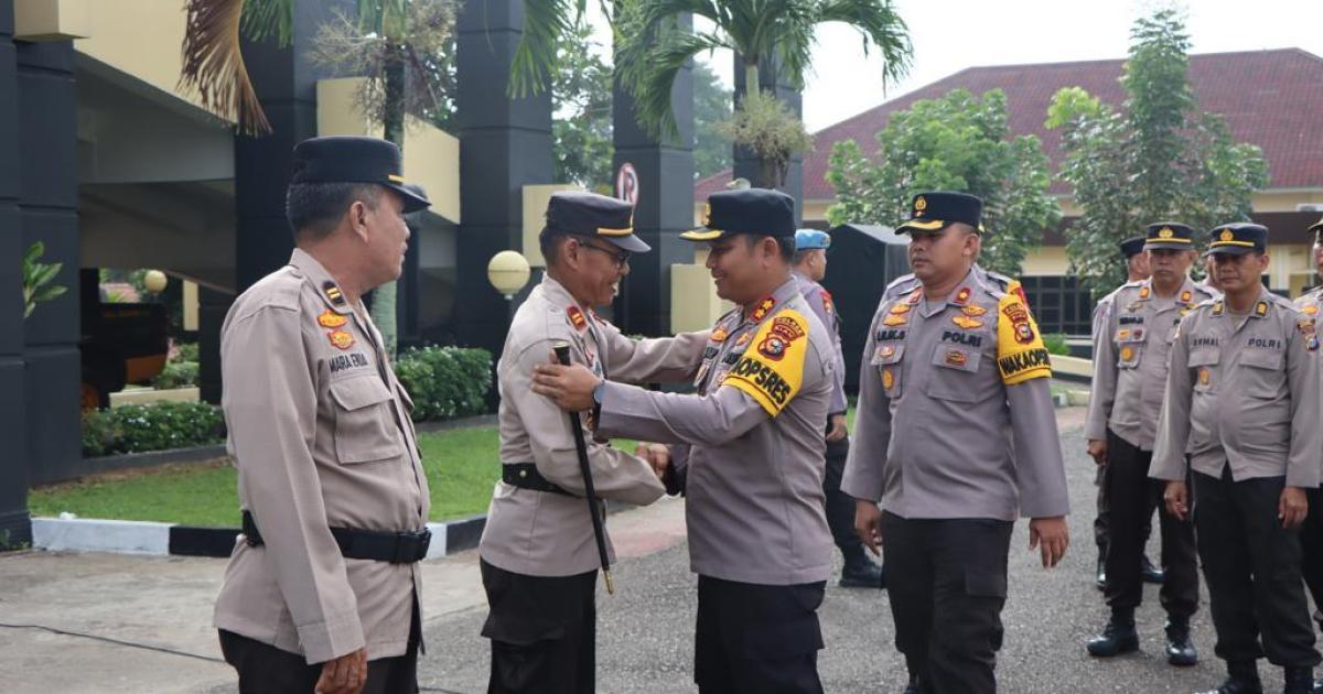 AKBP Pangucap menjabat tangan salah seorang personil yang purna bhakti