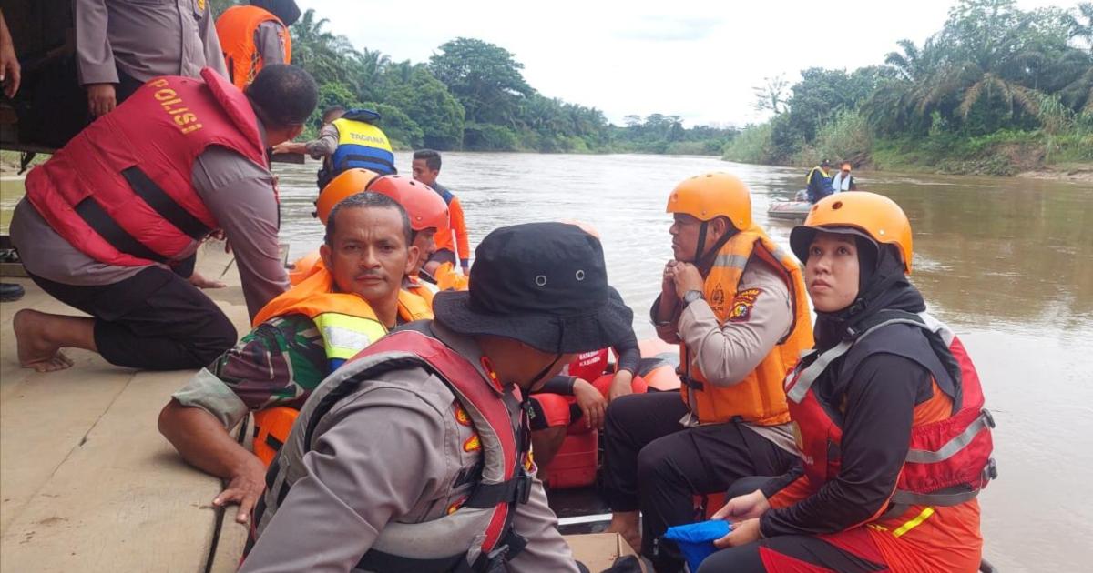 Personil menaiki perahu karet untuk mencari korban hanyut