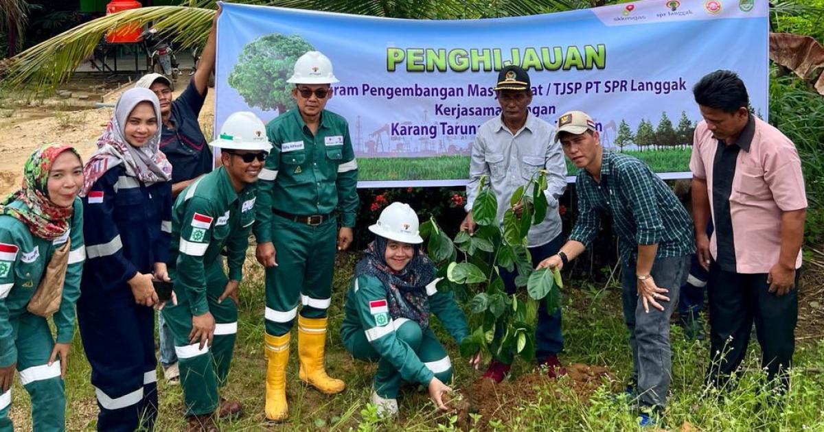 Yunida Mahpuzoh, Business Support Manager PT SPR Langgak sedang menanam pohon di pinggir jalan Desa Koto Tandun didampingi Muhammad Tohsin, Kepala Desa Koto Tandun (bertopi, dua dari kanan) dan staff PT SPR Langgak serta apartur desa.